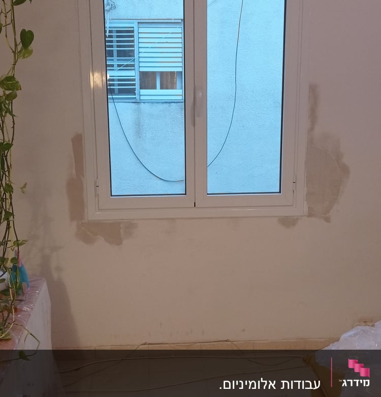 חלון אלומיניום עם מסגרת לבנה על קיר